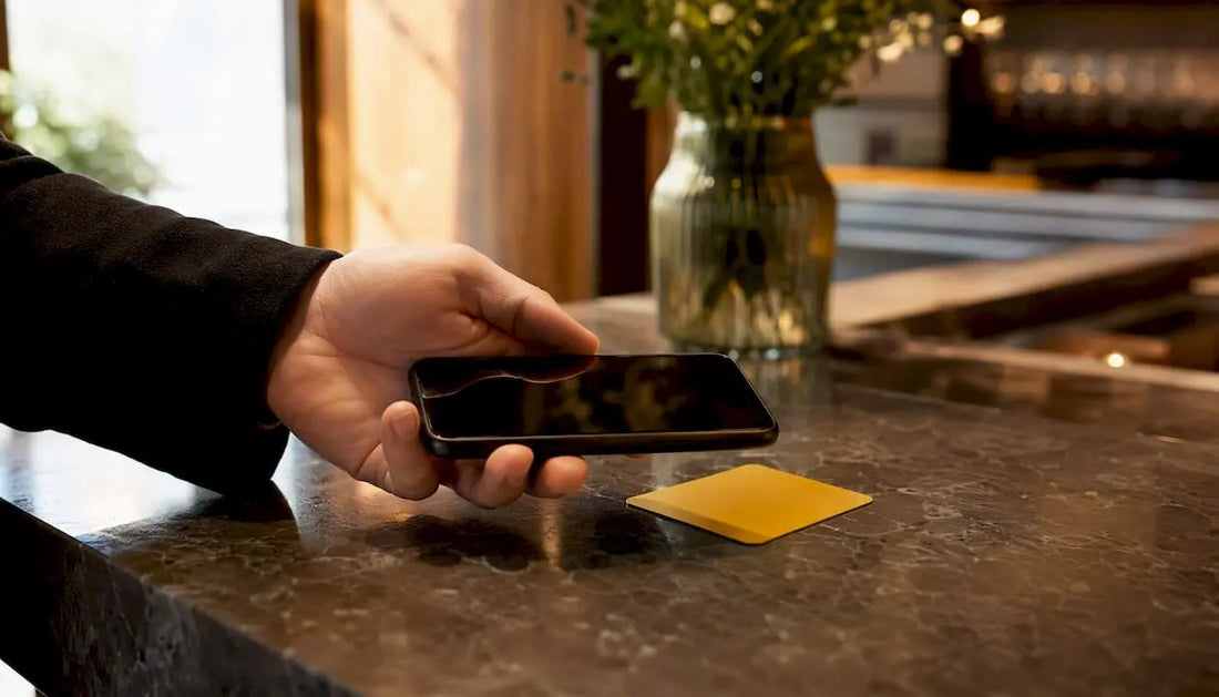 Eine Hand hält ein Smartphone und tippt es auf eine NFC-Bewertungskarte.