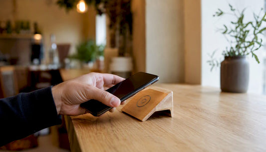 Eine Hand hält ein Smartphone und tippt es auf eine NFC-Bewertungskarte.