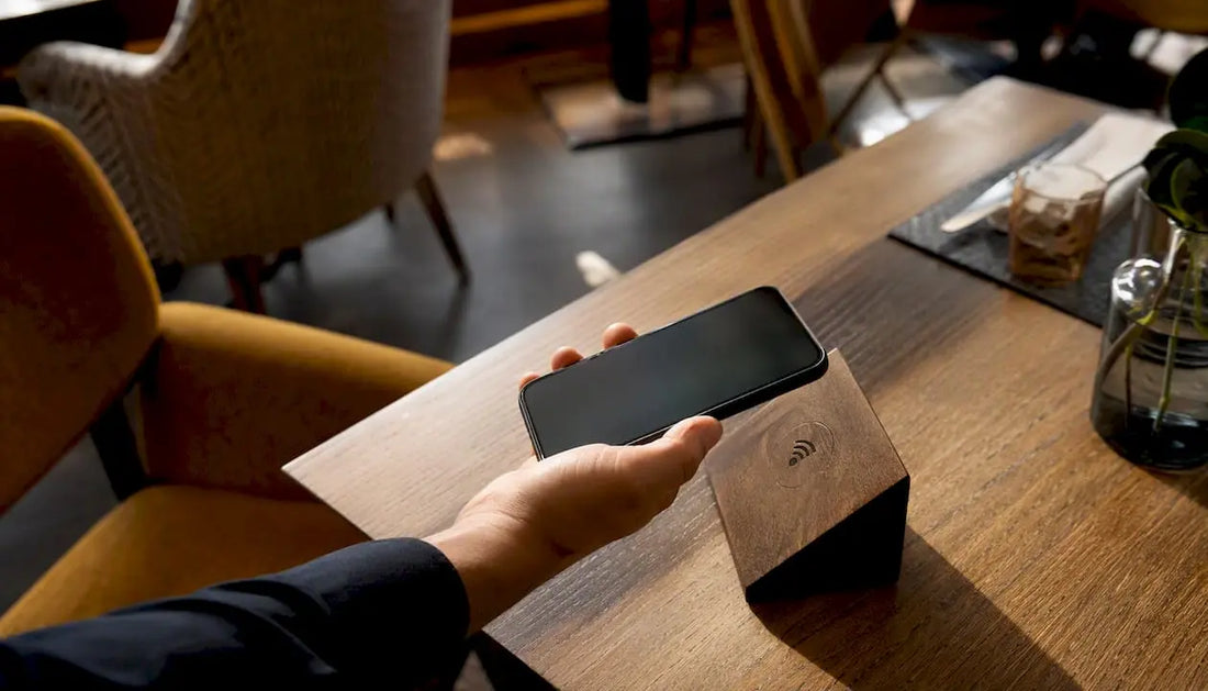 Eine Hand hält das Smartphone an einen NFC-Bewertungsstand und gibt direkt vor Ort eine Bewertung ab.