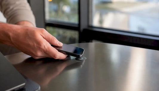 Nahaufnahme: Eine Hand hält ein Smartphone und tippt auf einen NFC-Tag.
